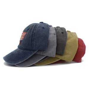 Detail of five distressed cotton baseball caps in various colors with American flag embroidery