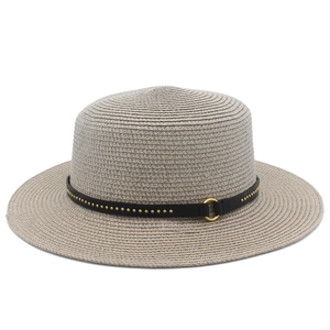Detail of straw boater hat featuring a studded black leather band and golden ring buckle