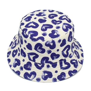 Detailed view of bucket hat stitching with dark blue heart prints on beige cotton fabric