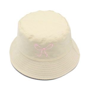 Detail view of pink bow embroidery and parallel stitching on a beige cotton bucket hat