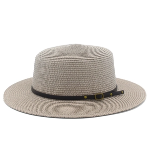 Detailed view of the woven texture and black leather strap on a beige boater hat