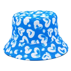 Detailed view of reinforced stitching on blue bucket hat with white heart pattern
