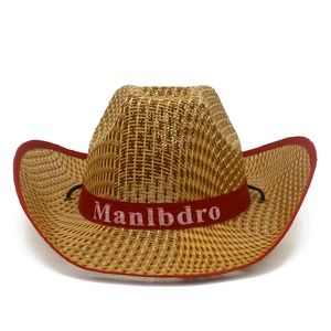 Détail d'un chapeau de cowboy en paille avec bordure rouge et ruban décoratif