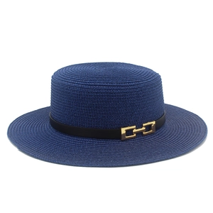 Dettaglio cappello di paglia blu navy con nastro nero e fibbia metallica a H dorata