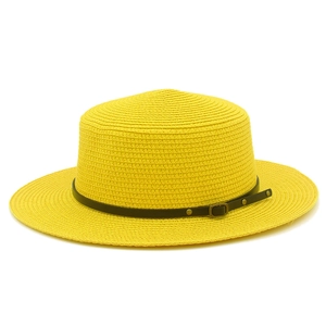 Close-up of woven straw hat featuring black leather band and antique bronze metal buckle
