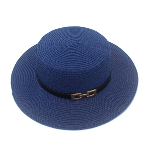 Dettaglio di un cappello di paglia blu navy con trama intrecciata e fibbia dorata
