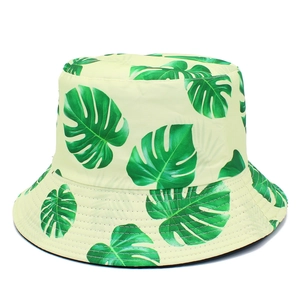 Unisex tropical bucket hat with green monstera leaf print on a light yellow base