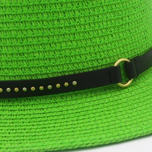 Macro shot of neon green straw hat with black leather belt and gold metal buckle detailing