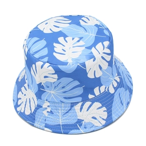 Detail of blue bucket hat featuring white tropical leaf patterns and multi-row brim stitching