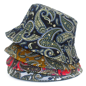 Vertical stack of navy blue, yellow, red, and white paisley bucket hats in twill cotton