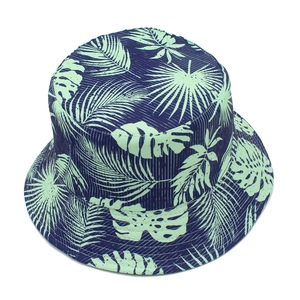 Detail of tropical palm leaf print bucket hat with navy base and white vertical stripes