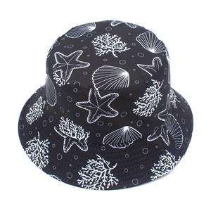 Detail of starfish and coral print on black cotton bucket hat with white pattern accents