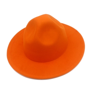 Détail d'un chapeau fedora orange vif en feutre avec bord large plat et surpiqûres
