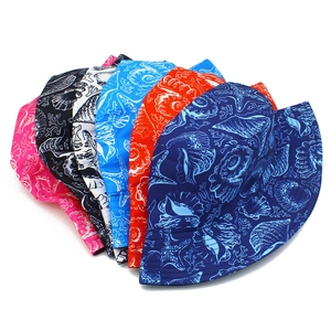 Flat lay of multiple summer bucket hats with colorful ocean creature prints on white surface