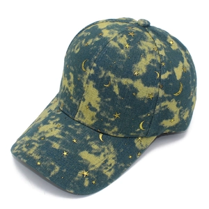 Detailed close-up of blue and yellow tie-dye baseball cap with gold stars and moon icons