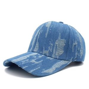 Close-up of distressed denim baseball cap featuring vintage ripped details and blue texture