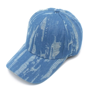 Detailed close-up of distressed blue denim baseball cap with vintage washed texture