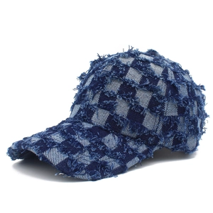 Detail of blue denim baseball cap with checkerboard pattern and frayed edge textures