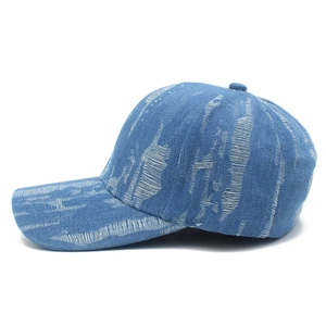 Detail shot of distressed dark blue denim baseball cap with vertical ripple texture