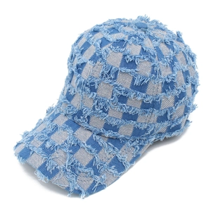 Detailed view of blue and grey checkerboard baseball cap with distressed frayed edges