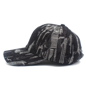 Close-up of distressed black denim baseball cap with vintage frayed and ripped details