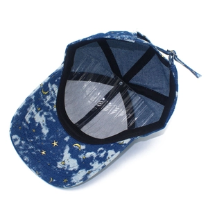 Internal view of denim cap showing metal buckle, sweatband, and star moon embroidery