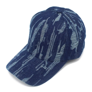 Detail of distressed navy denim baseball cap showing vintage frayed edges and torn fabric