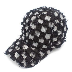 Detail of checkered baseball cap featuring distressed frayed edges and cotton canvas texture