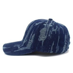 Detail shot of distressed blue denim baseball cap showing premium woven texture and stitching