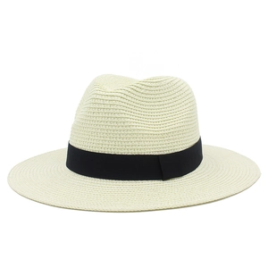 Close-up of beige straw sun hat featuring a classic black ribbon band and fine woven texture