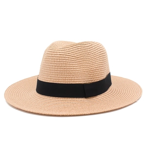 Close-up detail of the fine woven texture and black ribbon on a beige Panama straw hat