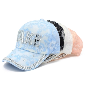 Dettagli di berretti in pizzo con lettere MAKE in strass e motivi floreali