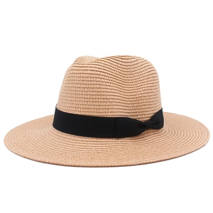 Detail of hand-woven straw texture and black decorative ribbon on sun hat