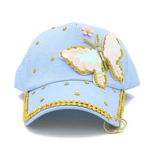 Detail of light blue baseball cap with sequin butterfly, pink flower and gold metal rings