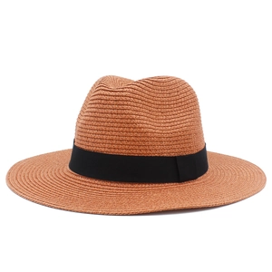 Close-up of caramel straw fedora hat featuring detailed spiral weave and black ribbon bow