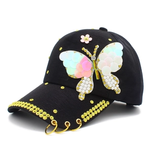 Black baseball cap with sequin butterfly, yellow rhinestones, and golden rings detail
