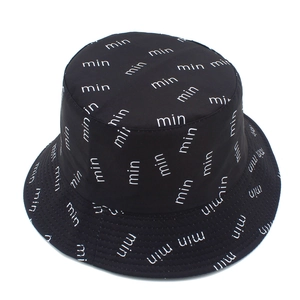Close-up of black bucket hat featuring white letter pattern and smooth texture