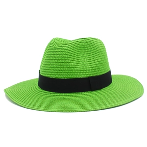 Detail of the neon green straw sun hat featuring a classic black ribbon and woven texture