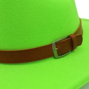 Dettaglio del cappello di lana verde neon con cinturino in similpelle marrone e fibbia
