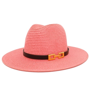 Dettaglio cappello di paglia rosa con nastro nero e fibbia in metallo dorato