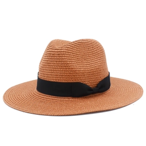 Close-up of brown woven straw hat with black grosgrain ribbon and classic bow detail