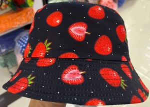 Détail d'un chapeau bob noir avec des motifs de fraises et des coutures renforcées