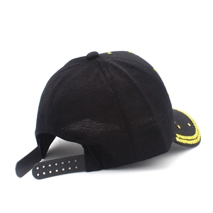 Detail of black baseball cap snapback closure and yellow rhinestone smiley face decoration