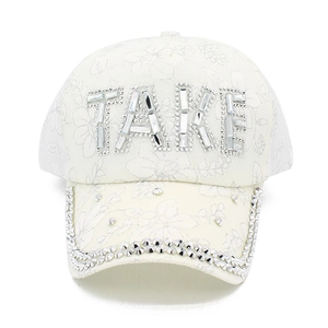 Dettaglio del cappello bianco con ricamo floreale e scritta TAKE in strass lucidi