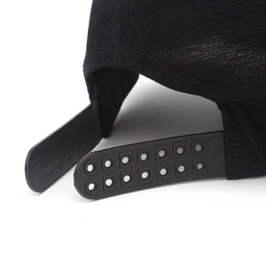 Detailed macro view of the black baseball cap showing the breathable fabric and snapback closure