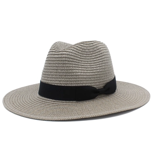 Close-up of light grey woven straw hat featuring a black decorative ribbon and bow