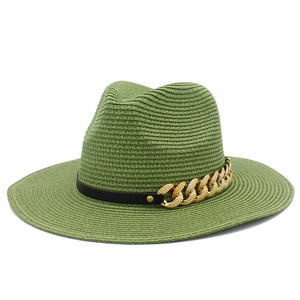 Détail d'un chapeau de paille vert avec ruban en cuir noir et chaîne dorée décorative