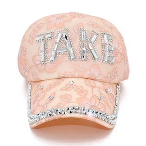 Dettaglio del cappellino in pizzo rosa con scritta TAKE in strass e ricamo floreale