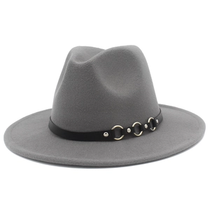 Dettaglio cappello fedora in feltro grigio con fascia in pelle, anelli dorati e borchie argentate