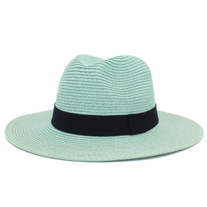 Close-up of mint green straw fedora hat featuring woven texture and black ribbon detail